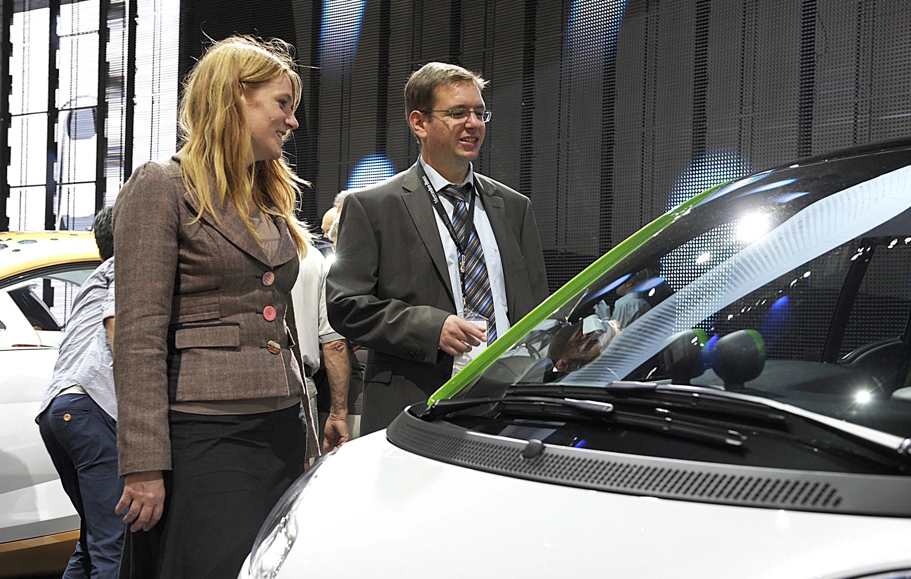 Iris Krampitz mit einer Person vor Elekroauto