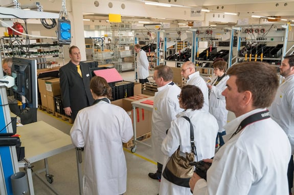 Several people in white coats during laboratory inspection